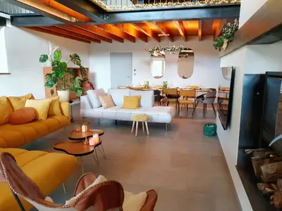 a living room with yellow furniture and a dining room at La ferme - Domaine Monbel in Mirepoix