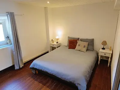 a bedroom with a bed with two night stands at La ferme - Domaine Monbel in Mirepoix