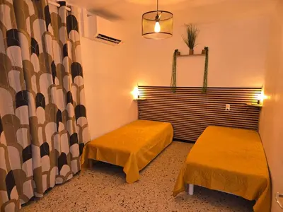 a small room with two beds and a window at Les sables d'or in Port-la-Nouvelle
