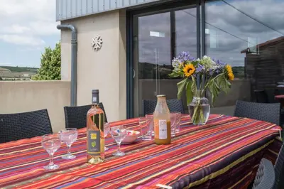 a table with wine bottles and glasses and flowers on it at Maison avec piscine privée à La Digne-d'Aval in La Digne-dʼAval