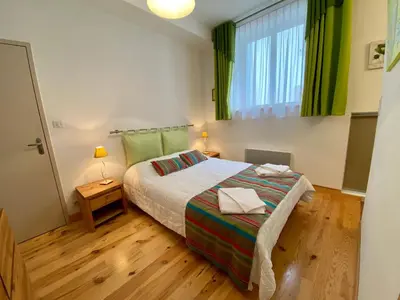 a bedroom with a bed and a window with green curtains at Maison avec piscine privée à La Digne-d'Aval in La Digne-dʼAval