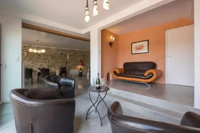 a living room with leather chairs and a table at Maison avec piscine privée à La Digne-d'Aval in La Digne-dʼAval