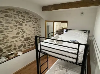 a bunk bed in a room with a stone wall at Chambre Le 40 marches in Cucugnan