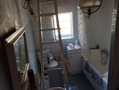 a bathroom with a ladder next to a toilet and a tub at Maison de campagne Les loirs in Lespinassière