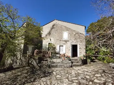 an old stone house with a door and a yard at Maison de campagne Les loirs in Lespinassière