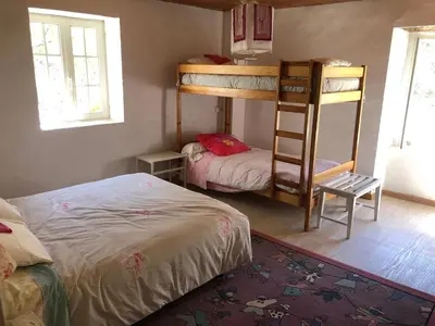 a bedroom with two bunk beds and a bed at Maison de campagne Les loirs in Lespinassière