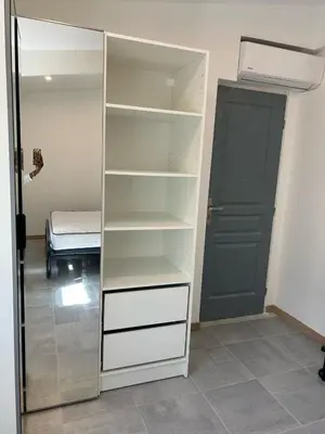 a closet with white shelves and a door and a bed at Gite à moins de 10 minutes de la cité médiévale de Carcassonne in Carcassonne