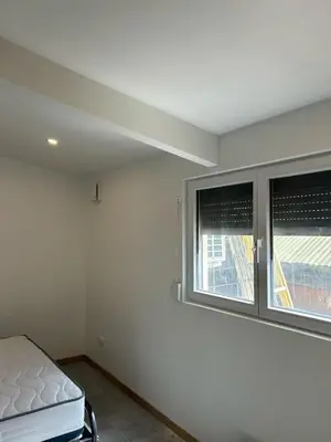 an empty room with two windows and a bed at Gite à moins de 10 minutes de la cité médiévale de Carcassonne in Carcassonne