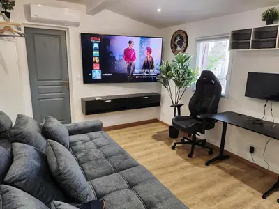 a living room with a couch and a flat screen tv at Gite à moins de 10 minutes de la cité médiévale de Carcassonne in Carcassonne