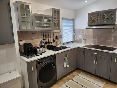 a kitchen with gray cabinets and a dishwasher at Gite à moins de 10 minutes de la cité médiévale de Carcassonne in Carcassonne