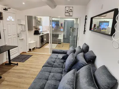 a living room with a large gray couch at Gite à moins de 10 minutes de la cité médiévale de Carcassonne in Carcassonne