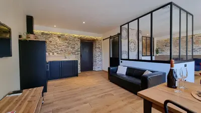 a living room with a couch and a table at Le Relais de Diligence Balnéo & Sauna in Salsigne
