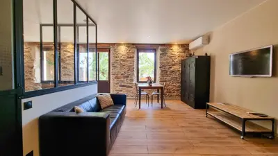 a living room with a couch and a table at Le Relais de Diligence Balnéo & Sauna in Salsigne