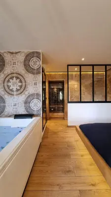a room with a bed and a hallway at Le Relais de Diligence Balnéo & Sauna in Salsigne