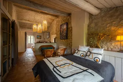 a bedroom with a large bed in a room at Prieuré Saint-Louis Maison d'Hôtes in Floure
