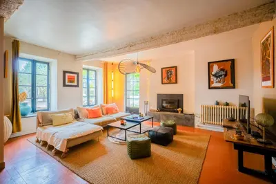 a living room with a couch and a fireplace at Prieuré Saint-Louis Maison d'Hôtes in Floure