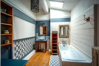 a bathroom with a tub and a sink at Prieuré Saint-Louis Maison d'Hôtes in Floure
