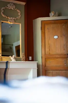 a room with a mirror and a wooden door at Prieuré Saint-Louis Maison d'Hôtes in Floure