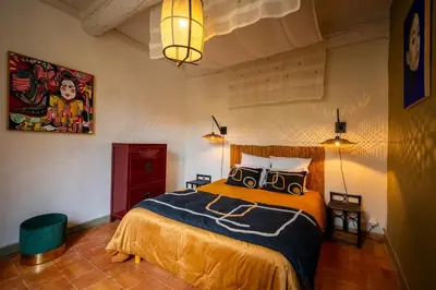 a bedroom with a bed with two speakers on it at Prieuré Saint-Louis Maison d'Hôtes in Floure