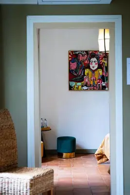 a living room with a painting on the wall at Prieuré Saint-Louis Maison d'Hôtes in Floure