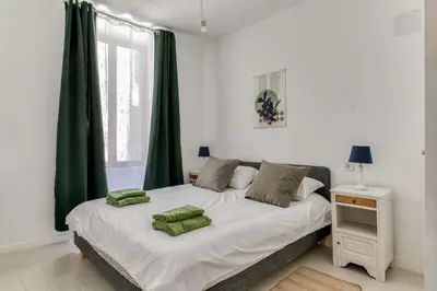 a bedroom with a bed with green pillows on it at L'Alchémille Terrasse Wifi in Peyriac-de-Mer