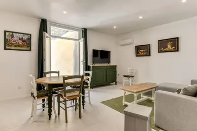 a living room with a table and a couch at L'Alchémille Terrasse Wifi in Peyriac-de-Mer