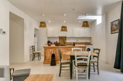 a kitchen and dining room with a table and chairs at L'Alchémille Terrasse Wifi in Peyriac-de-Mer