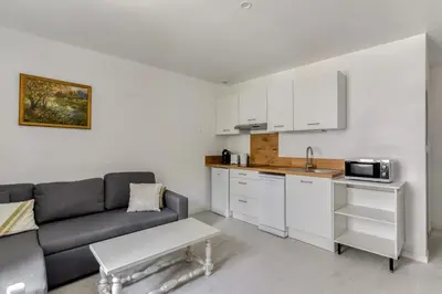 a living room with a couch and a kitchen at Le Bambou Wifi Proche des pontons et du Doul in Peyriac-de-Mer