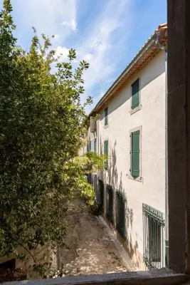 an alley way between two buildings with a tree at Le Bambou Wifi Proche des pontons et du Doul in Peyriac-de-Mer