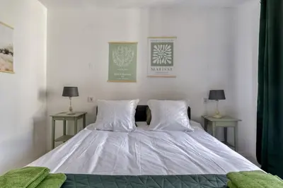 a bedroom with a bed with two tables and two lamps at Le Bambou Wifi Proche des pontons et du Doul in Peyriac-de-Mer