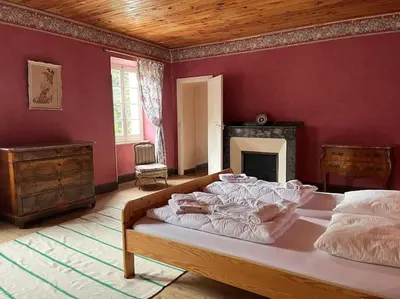 a bedroom with a large bed in a red wall at Demeure Familiale du 19ème Siècle in Bram
