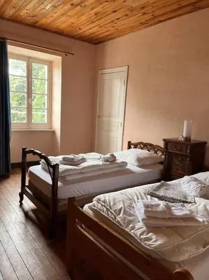 a bedroom with two beds and a window at Demeure Familiale du 19ème Siècle in Bram