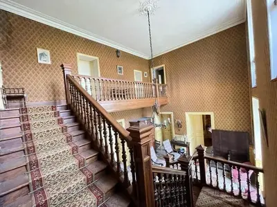 a room with a staircase and a living room at Demeure Familiale du 19ème Siècle in Bram