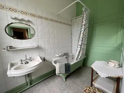 a bathroom with a sink and a mirror at Demeure Familiale du 19ème Siècle in Bram
