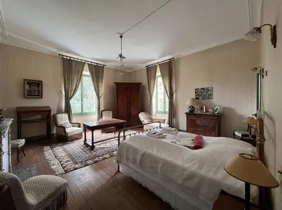 a bedroom with a bed and a table and chairs at Demeure Familiale du 19ème Siècle in Bram