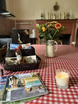 a table with a vase of flowers and a candle at Demeure Familiale du 19ème Siècle in Bram