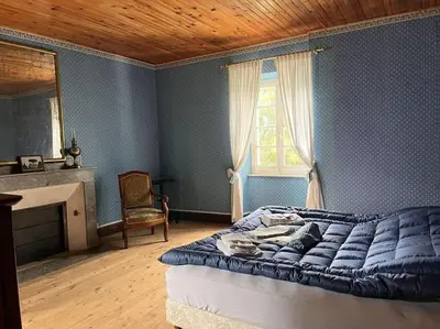 a bedroom with a large bed and a window at Demeure Familiale du 19ème Siècle in Bram