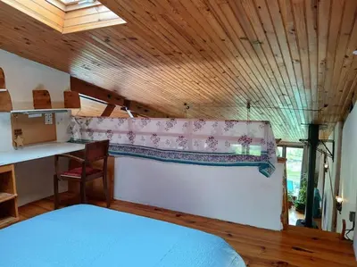a bedroom with a bed and a desk in a room at Bright loft with mountain and nature view in Sougraigne