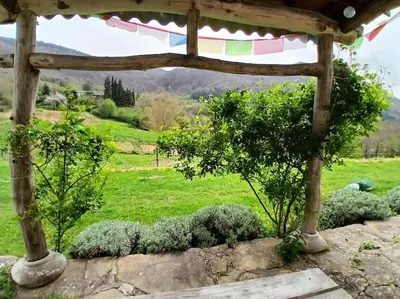 a wooden pergola with a view of a field at Bright loft with mountain and nature view in Sougraigne