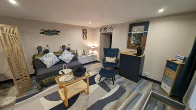 a living room with a bed and a chair at Studio 35m², Terrasse & Cuisine proche Carcassonne in Montclar