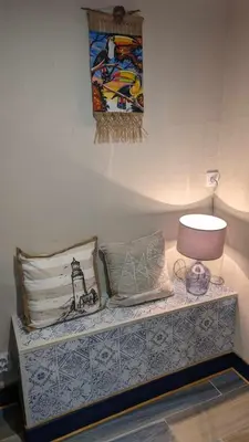 a bench with pillows and a lamp and a painting at Studio 35m², Terrasse & Cuisine proche Carcassonne in Montclar