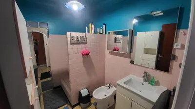 a pink bathroom with a sink and a toilet at Bel Appartement in Vinassan