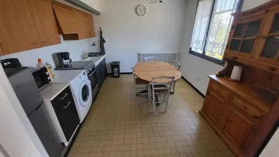 a kitchen with a table and a table and a washing machine at Bel Appartement in Vinassan