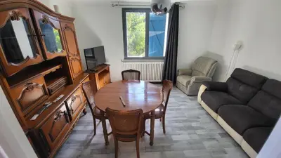 a living room with a table and a couch at Bel Appartement in Vinassan
