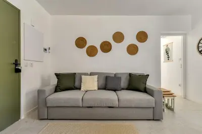 a living room with a gray couch in a room at Le Cyperus Appartement avec Terrasse et Wifi in Peyriac-de-Mer