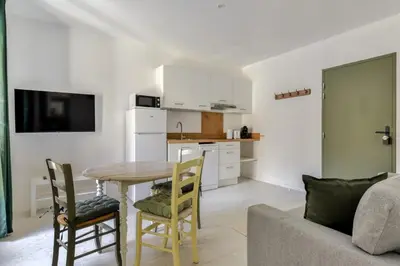a kitchen and dining room with a table and chairs at Le Cyperus Appartement avec Terrasse et Wifi in Peyriac-de-Mer