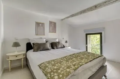 a white bedroom with a large bed and a window at Le Dichondra Wifi Proche des Pontons in Peyriac-de-Mer