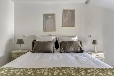 a bedroom with a bed with two tables and two lamps at Le Dichondra Wifi Proche des Pontons in Peyriac-de-Mer