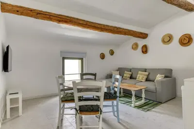 a living room with a couch and a table and chairs at Le Dichondra Wifi Proche des Pontons in Peyriac-de-Mer