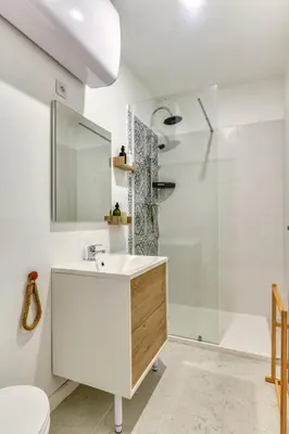 a bathroom with a white sink and a shower at L'Euphorbe Terrasse Wifi in Peyriac-de-Mer